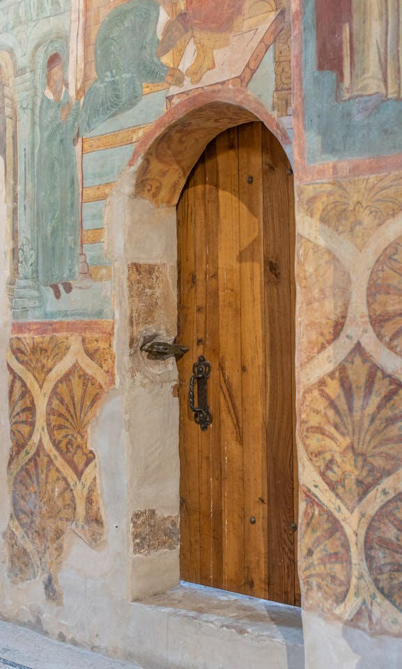 Picture of a wood door with worn depiction of a Gospel scene