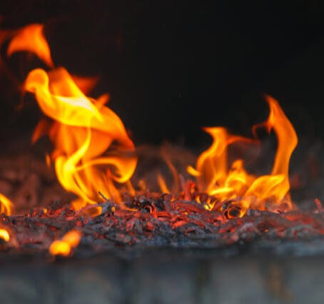A bed of coals with fire licking the air above it.